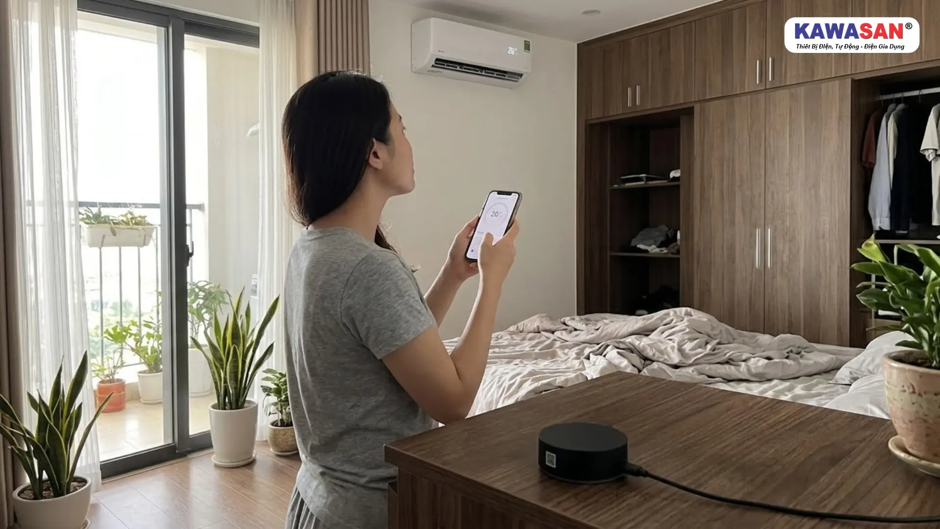 Người phụ nữ kiểm tra máy lạnh hiển thị 26°C sau khi thao tác trên điện thoại.