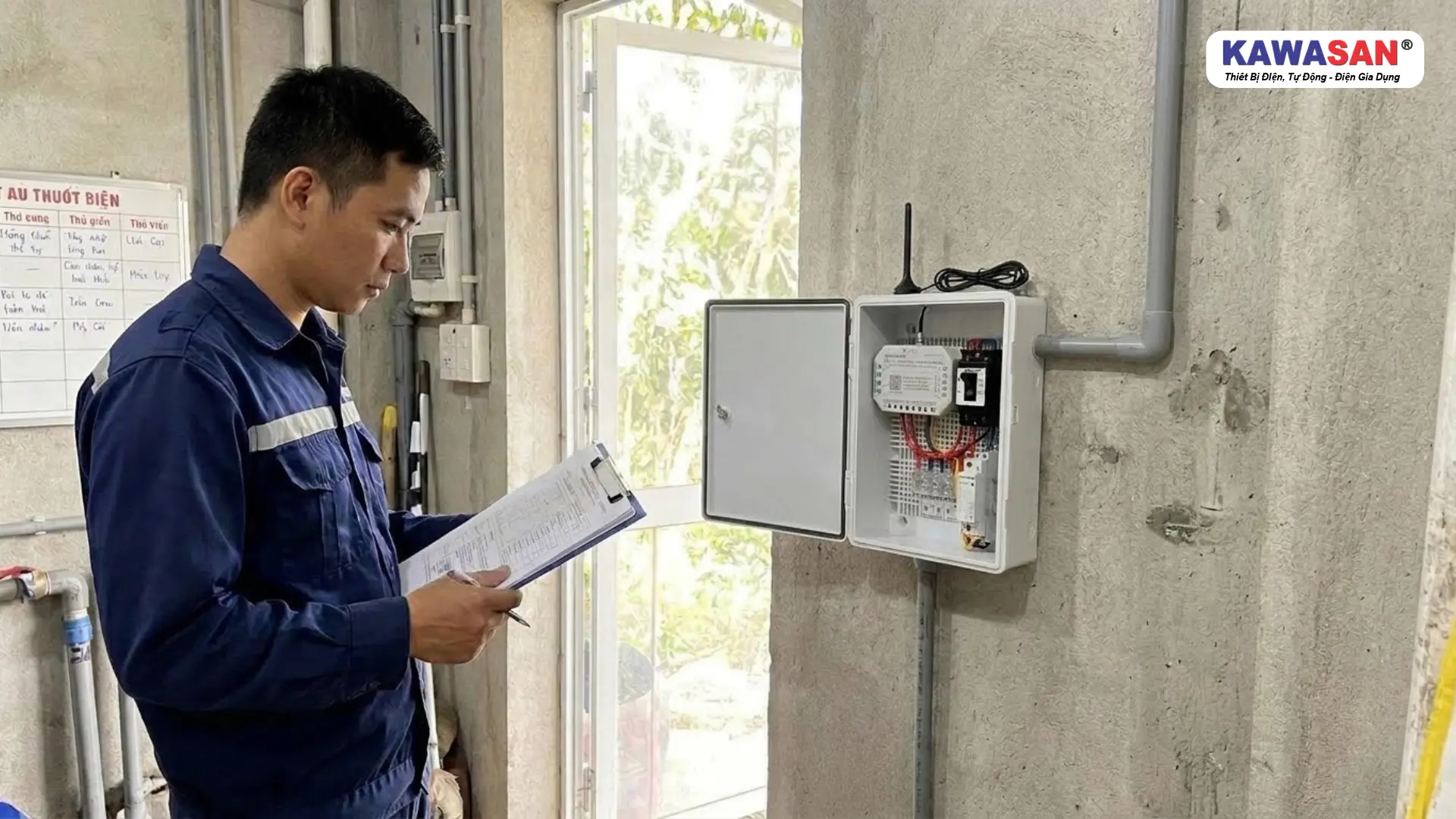 Kỹ thuật viên kiểm tra tài liệu kỹ thuật cạnh tủ điều khiển 4G KAWASAN mở cửa