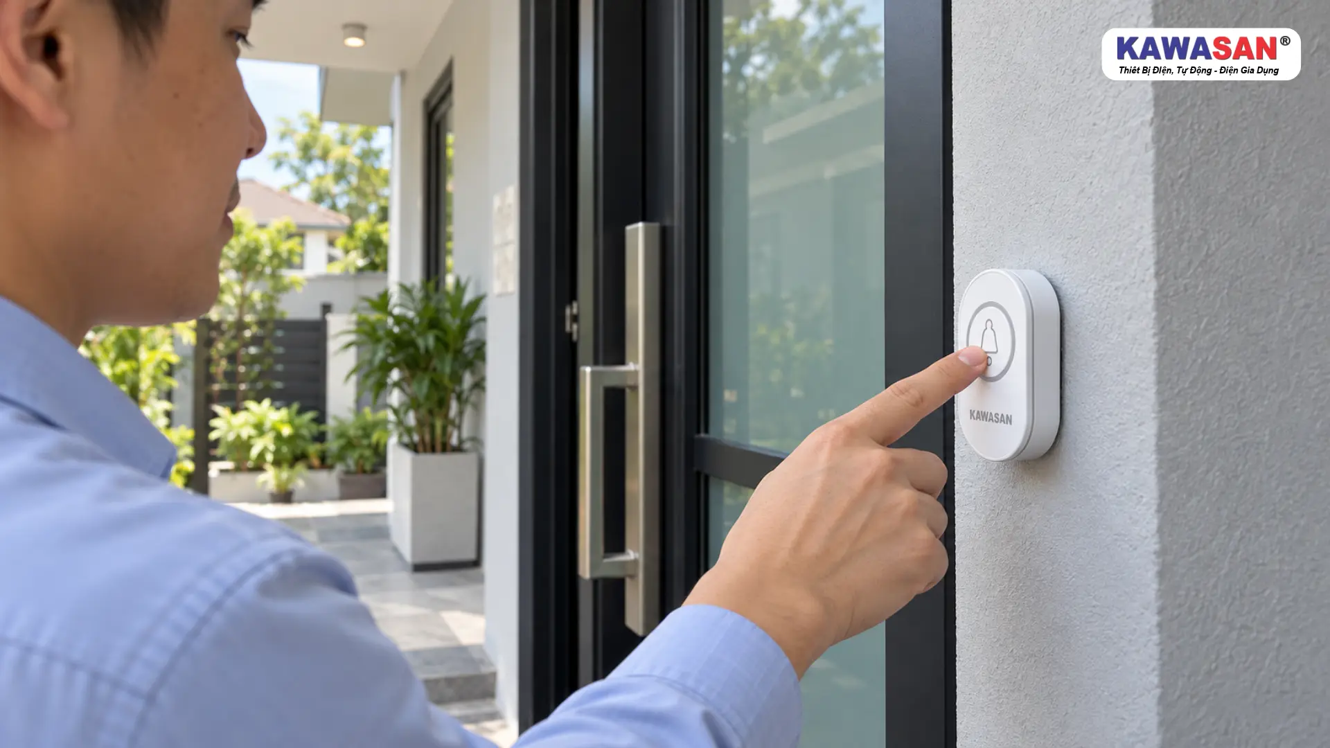 Người khách nhấn nút chuông cửa không dây KAWASAN trên tường cạnh cửa kính.